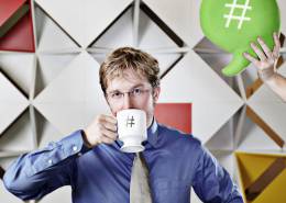 مردی در حال نوشیدن چای و علامت هشتگ روی سر آن